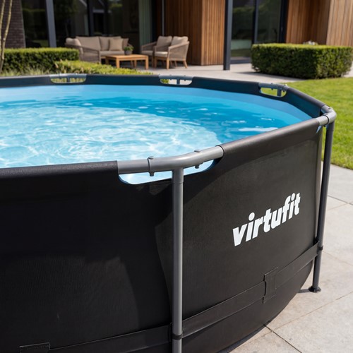 Lifestyle afbeelding van het ronde zwarte VirtuFit Zwembad in een tuinsetting met een duidelijke weergave van het witte logo en het frame.