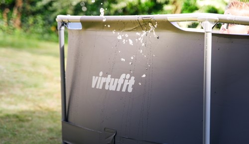 Detailopname van de duurzame grijze liner en het VirtuFit logo van het ronde frame zwembad met waterspatten.