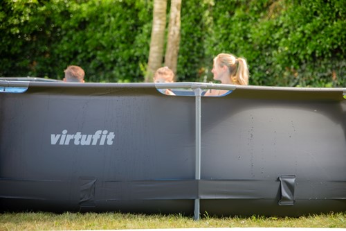 Lifestyle zijaanzicht van het VirtuFit ronde zwembad van 366 x 76 cm geplaatst op een gazon in een groene omgeving.