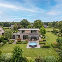 Lifestyle afbeelding van het ronde VirtuFit zwembad antraciet geplaatst in een grote moderne tuin met een luxe uitstraling.